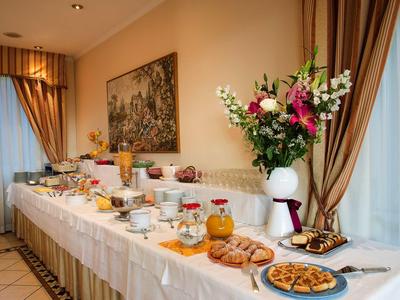 Elegantes Buffet mit Gebäck, Saft und Blumen in einem gemütlichen Hotelzimmer.