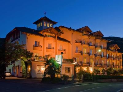 Beleuchtetes Hotelgebäude bei Abenddämmerung vor dunklem Himmel.