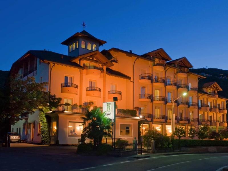 Edificio dell'hotel illuminato con balconi di notte contro il cielo scuro.