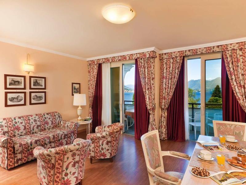 Cozy living area with floral furniture and view of balcony and lake