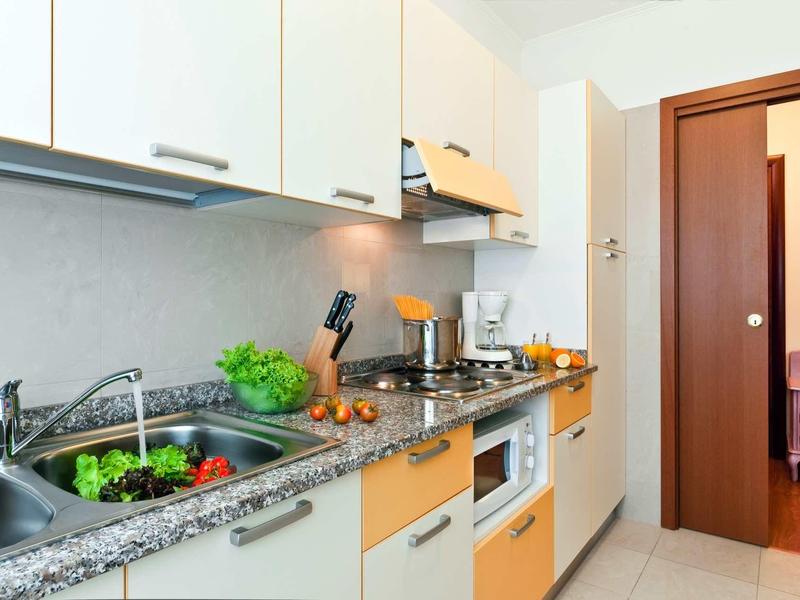 Modern bright kitchen with granite countertop and built-in appliances in a vacation rental.