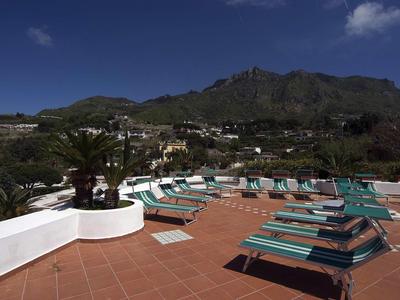 Dachterrasse mit Liegestühlen und Bergblick unter klarem Himmel