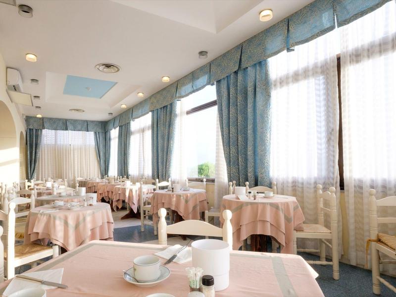 Bright, airy dining room with large windows and set tables.