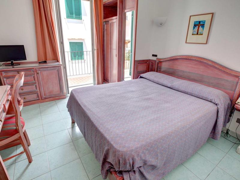 Chambre d'hôtel confortable avec lit double, télévision, bureau et balcon.