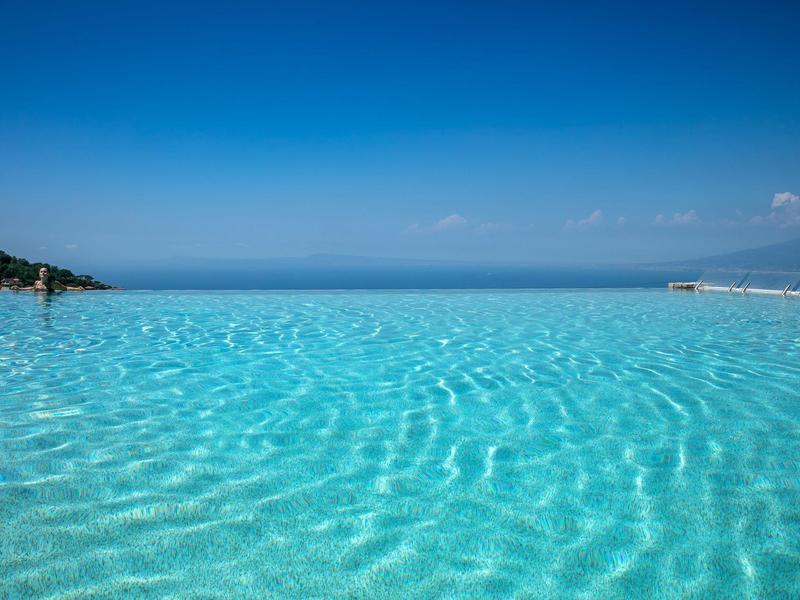 Unendlicher Pool mit klarem Wasser und blauem Himmel am Meer