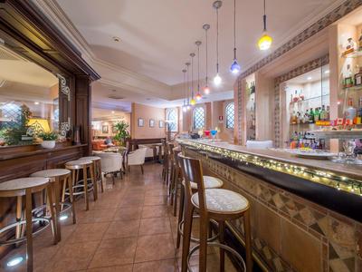 Innenansicht einer gemütlichen Hotelbar mit Holzhockern und dezenter Beleuchtung.
