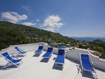 Terrasse mit blauen Liegestühlen und Bergblick bei klarem Himmel