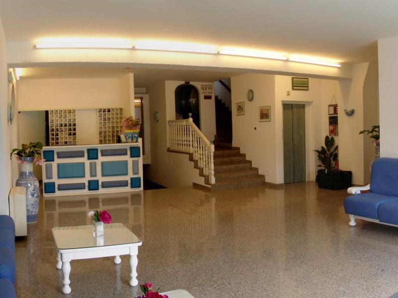 Atrio dell'hotel con reception, scala e posti a sedere in una stanza luminosa.