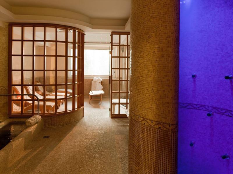 Wellness prostor s dřevěnou saunou a modře osvětlenou parní místností