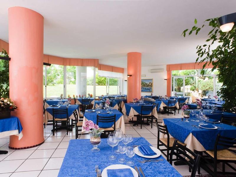 Ruime lichte eetzaal met blauwe tafelkleden en oranje kolommen