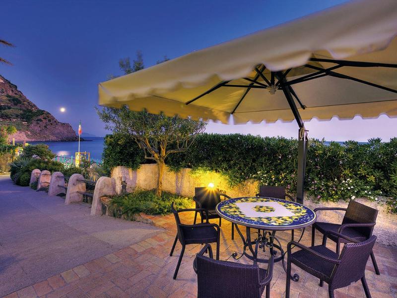 Taras wieczorny z stołem i krzesłami pod parasolem w hotelu