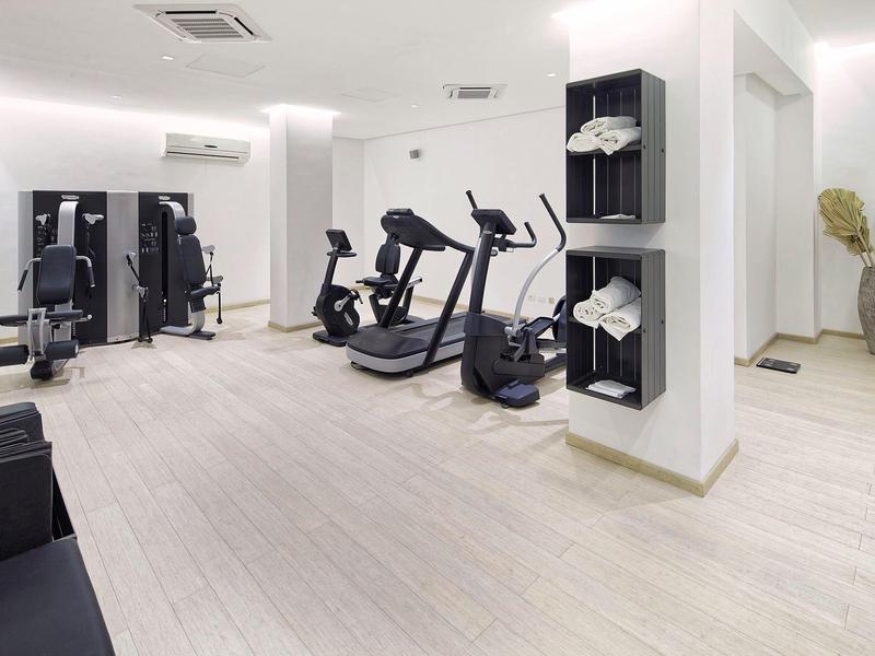 Nowoczesna siłownia z różnymi urządzeniami i jasną drewnianą podłogą