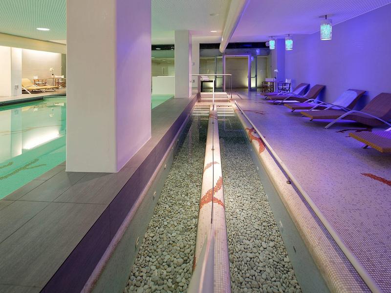Wewnętrzny basen z leżakami i relaksującym oświetleniem w hotelu