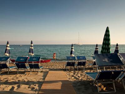 Spiaggia vuota con lettini e ombrelloni all'alba o al tramonto.