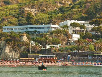 Hotelový komplex na svahu s pláží a lehátky u vody