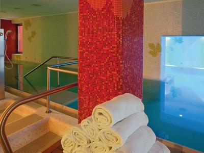 Vnitřní prostor s vířivkou, schody a bílými ručníky na recepci nebo ve wellness