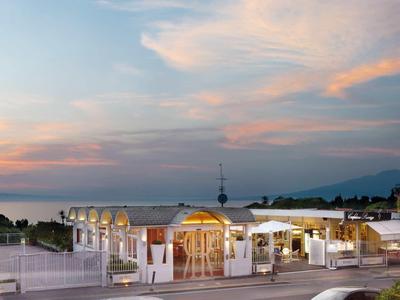 Nowoczesny pawilon z oświetleniem na wybrzeżu o zachodzie słońca pod niebieskim niebem.