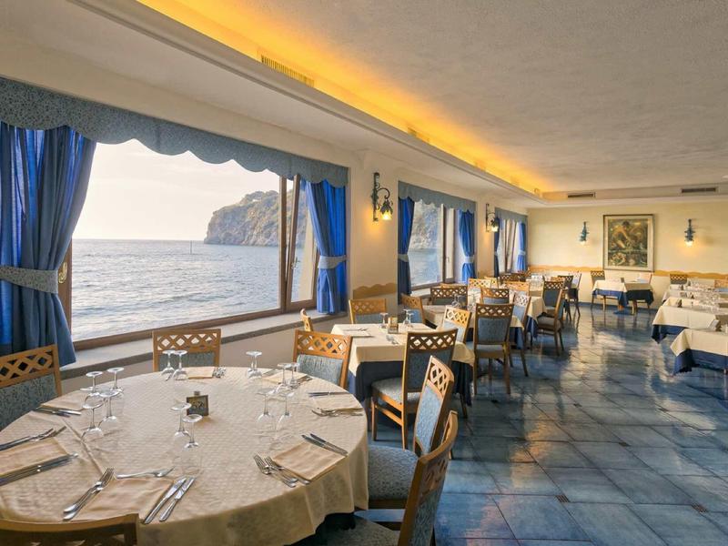 Ristorante elegante con grandi finestre con vista sul mare e sulle scogliere.