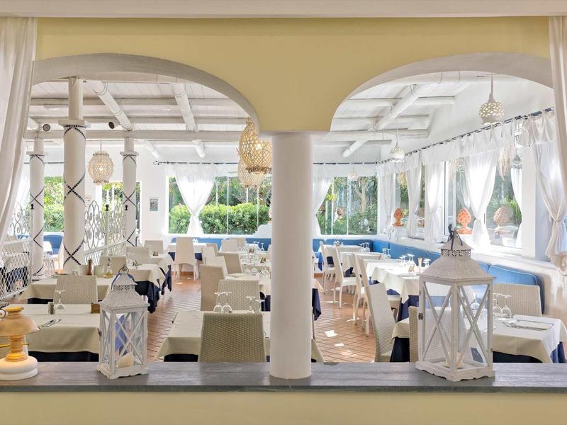 Elegante sala da pranzo con tende bianche e lanterne di stile, perfetta per i pasti in vacanza.