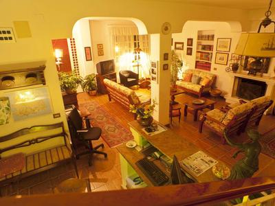 Příjemný obývací pokoj s teplým osvětlením, pohovkou, křesly a krbem v klasickém stylu.