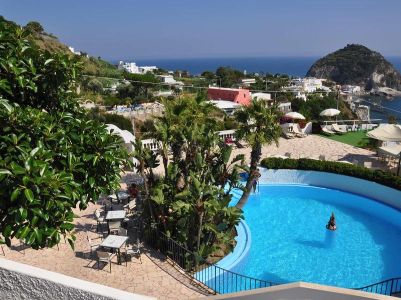 Rond zwembad met blauw water in een tropisch hotel met uitzicht op zee.