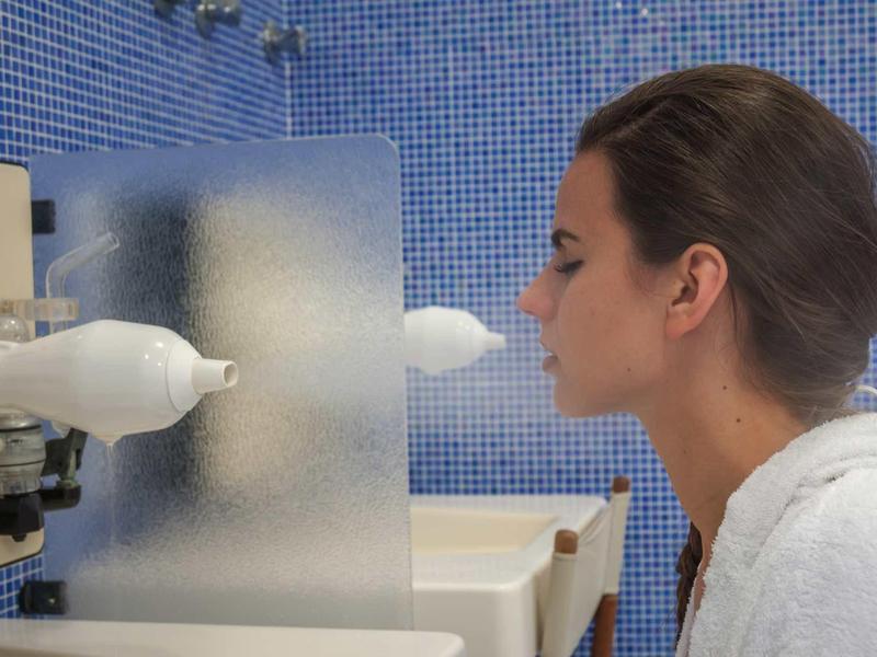 Een vrouw test met een neussprayapparaat in een laboratoriumomgeving.