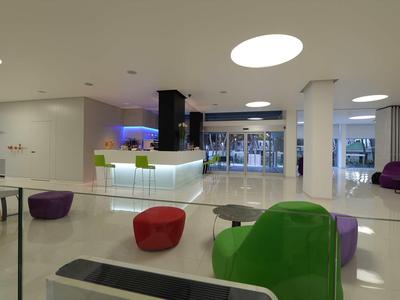 Moderner Hotel-Lobby-Bereich mit bunten Sitzgelegenheiten und hellem, offenem Design.