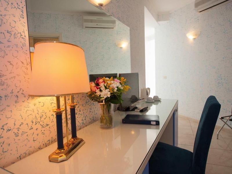 Moderne bureau met lamp, bloemen en tv in een lichte kamer.