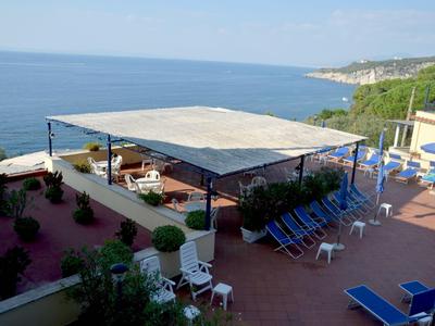 Terrasse mit blauen Liegestühlen und Blick auf das Meer an einem sonnigen Tag.
