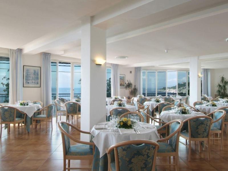 Elegancka restauracja z drewnianą podłogą i nakrytymi stołami z widokiem na morze