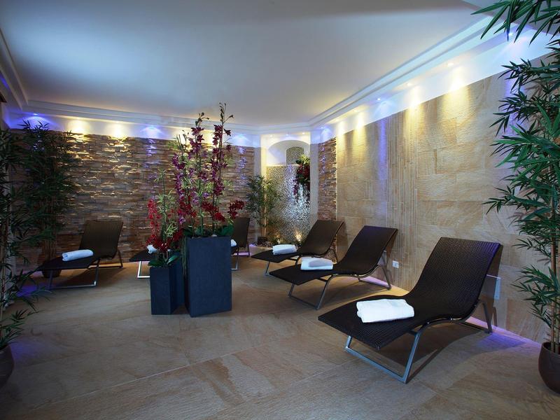Elegant wellness room with lounge chairs, soft lighting, and plants for relaxation.