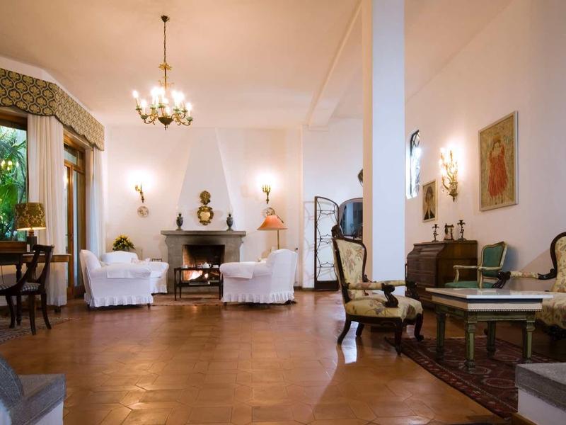 Elegant living room with antique furniture and chandelier in a classic hotel.