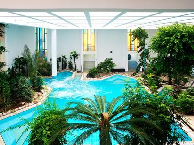 Piscine intérieure dans un hôtel moderne avec des plantes et de grandes fenêtres