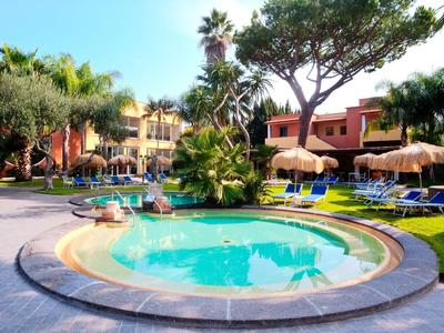 Piscine ronde avec parasols et chaises longues dans un jardin d'hôtel tropical