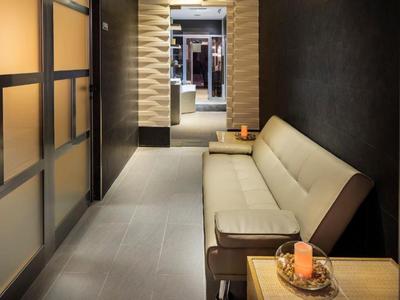 Nowoczesny korytarz hotelowy z długą beżową sofą i dekoracyjnymi elementami.