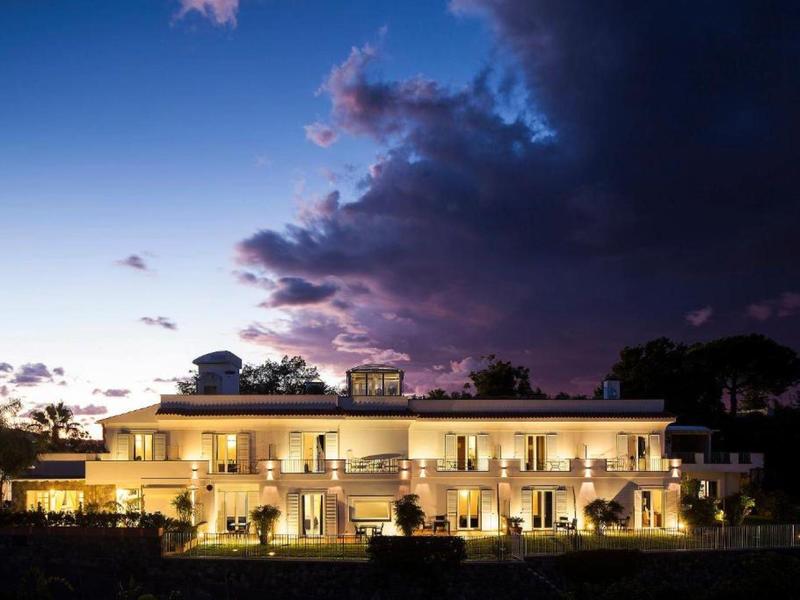 Nowoczesny budynek hotelowy o zmierzchu z oświetlonymi pokojami i ciemnym niebem