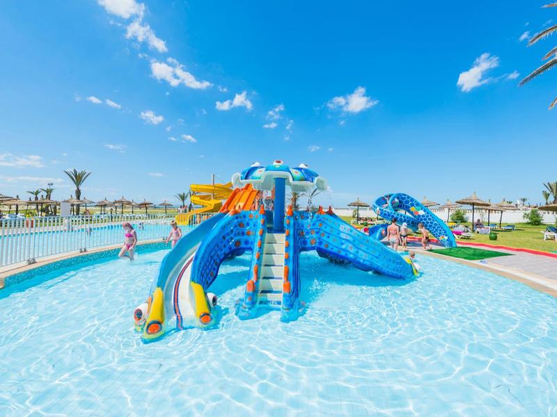 Park wodny z kolorowymi zjeżdżalniami i basenem dla dzieci pod błękitnym niebem