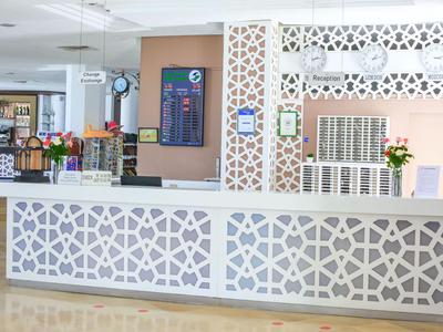 Nowoczesna recepcja z dekoracyjnym białym kontuarem i kwiatowymi aranżacjami