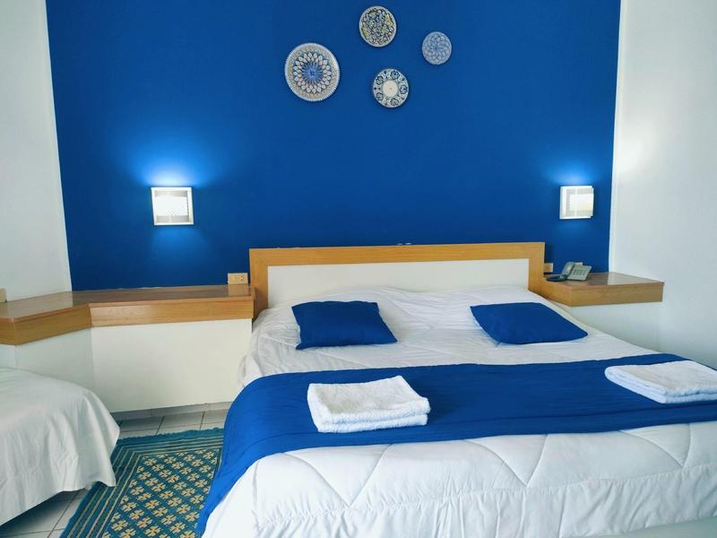 Modern hotelkamer met blauw-witte kleurenschema en decoratieve borden aan de muur