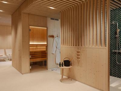 Espace bien-être moderne avec sauna, douche et chaises longues en tons bois neutres.
