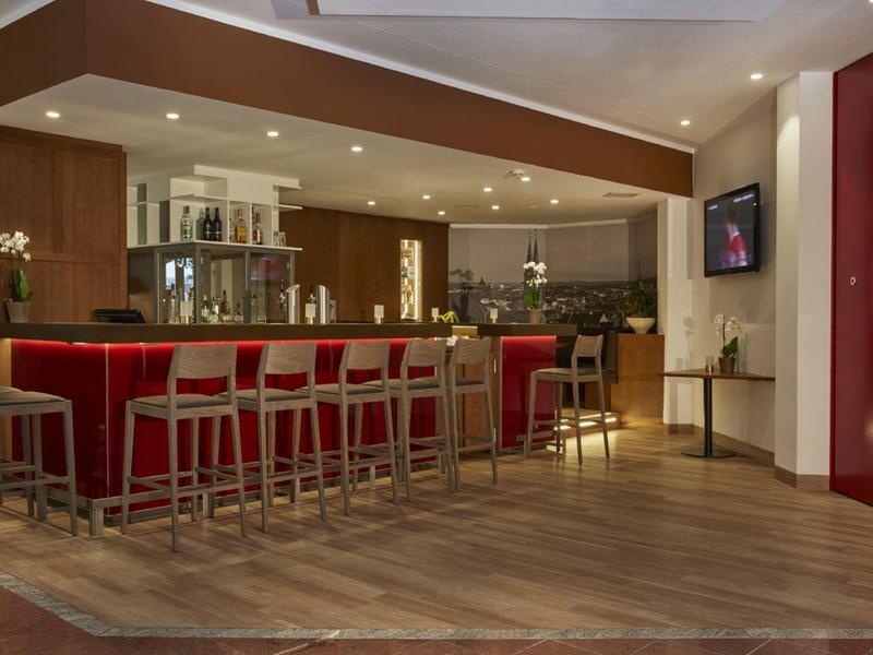 Nowoczesny bar hotelowy z drewnianymi stołkami i ciepłą atmosferą.