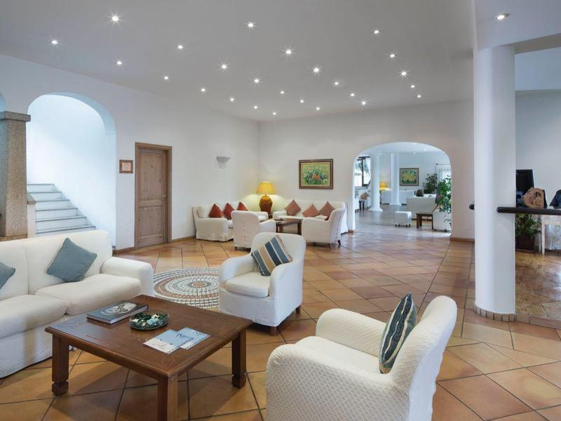 Helle Hotellobby mit gemütlichen Sofas, Rezeption und Pflanzen in modernem Design.