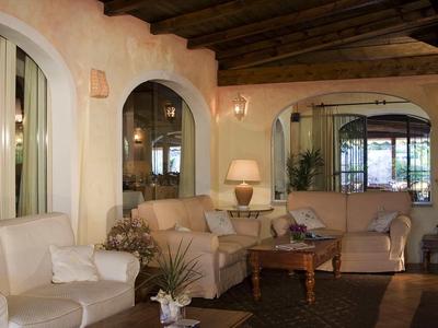 Gemütliches Wohnzimmer mit beigen Sofas, Holztisch, Teppich und warmem Holzdecken-Design.