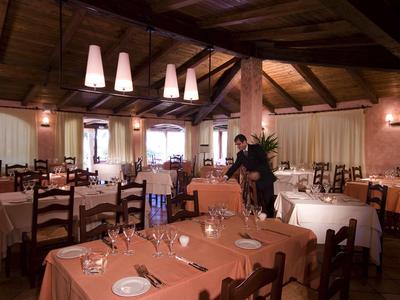 Rustikales Restaurant mit Holzbalkendecke, orange gedeckten Tischen und stilvoll arrangiertem Besteck.