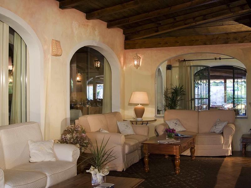 Gemütliches Wohnzimmer mit beigen Sofas, Holztisch, Teppich und warmem Holzdecken-Design.