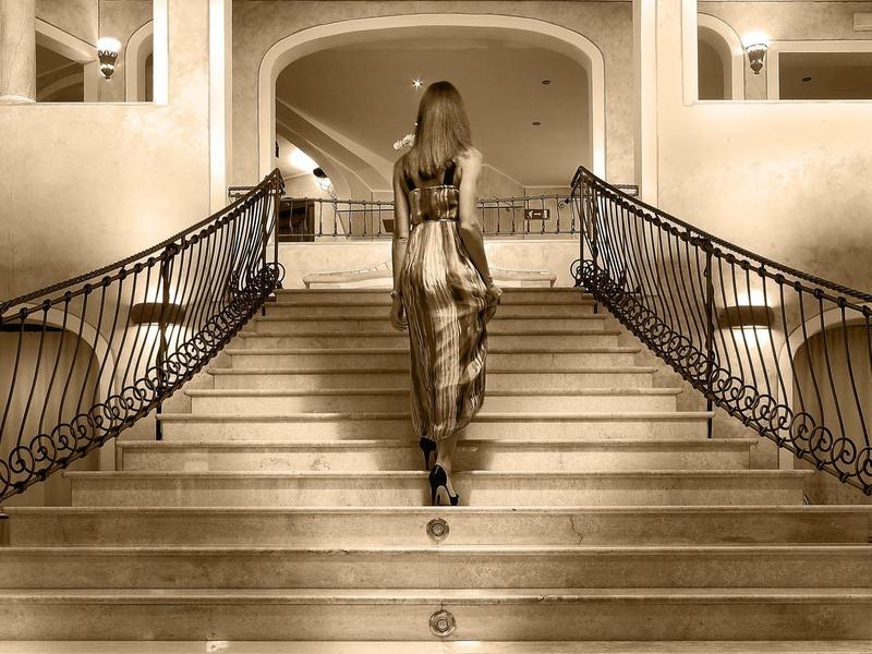 Hotelanlage mit Strand, Liegestühlen und klarem Wasser an einer Felsküste