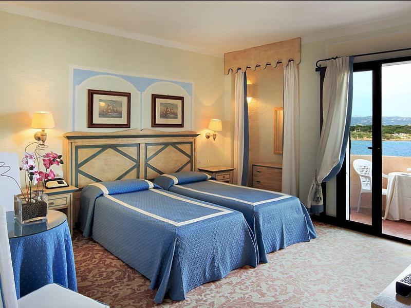 Hotelzimmer mit zwei Einzelbetten, Balkon mit Blick auf den Pool und das Meer