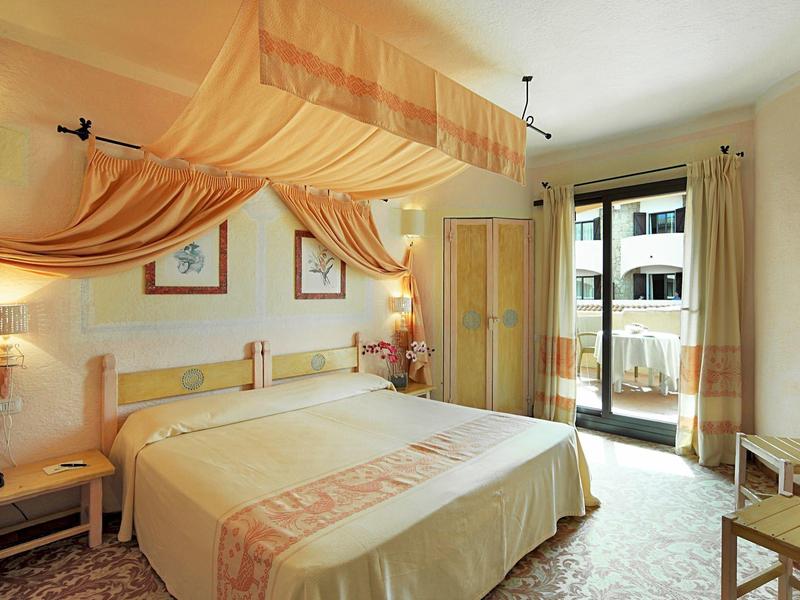 Helles Schlafzimmer mit Himmelbett, Balkon und stimmungsvoller Beleuchtung.