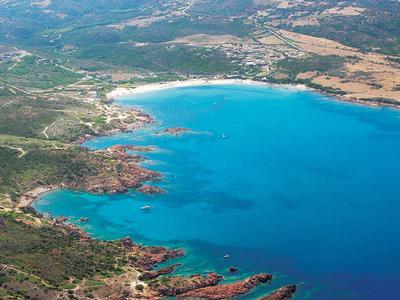Landschaft mit einer großen Bucht, blauem Wasser, weißen Sandstränden und grüner Vegetation.