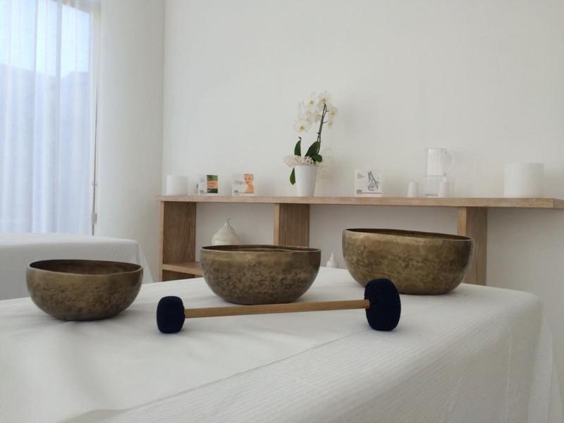 Trois bols bruns sur un tissu blanc avec une étagère en bois et une décoration blanche en arrière-plan.